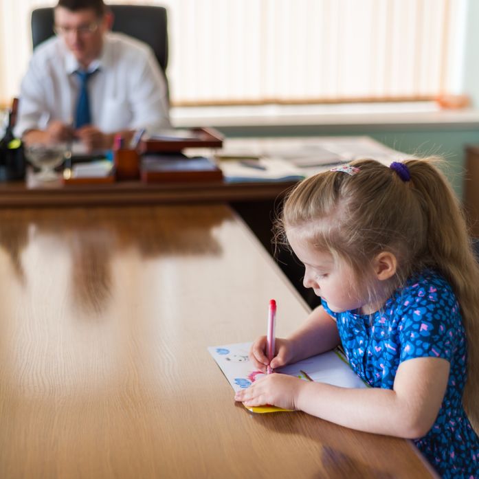 Vater und Tochter sitzen gemeinsam arbeitend am Schreibtisch 